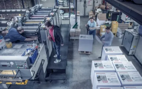 Commercial print floor with offset presses and finished print stacks