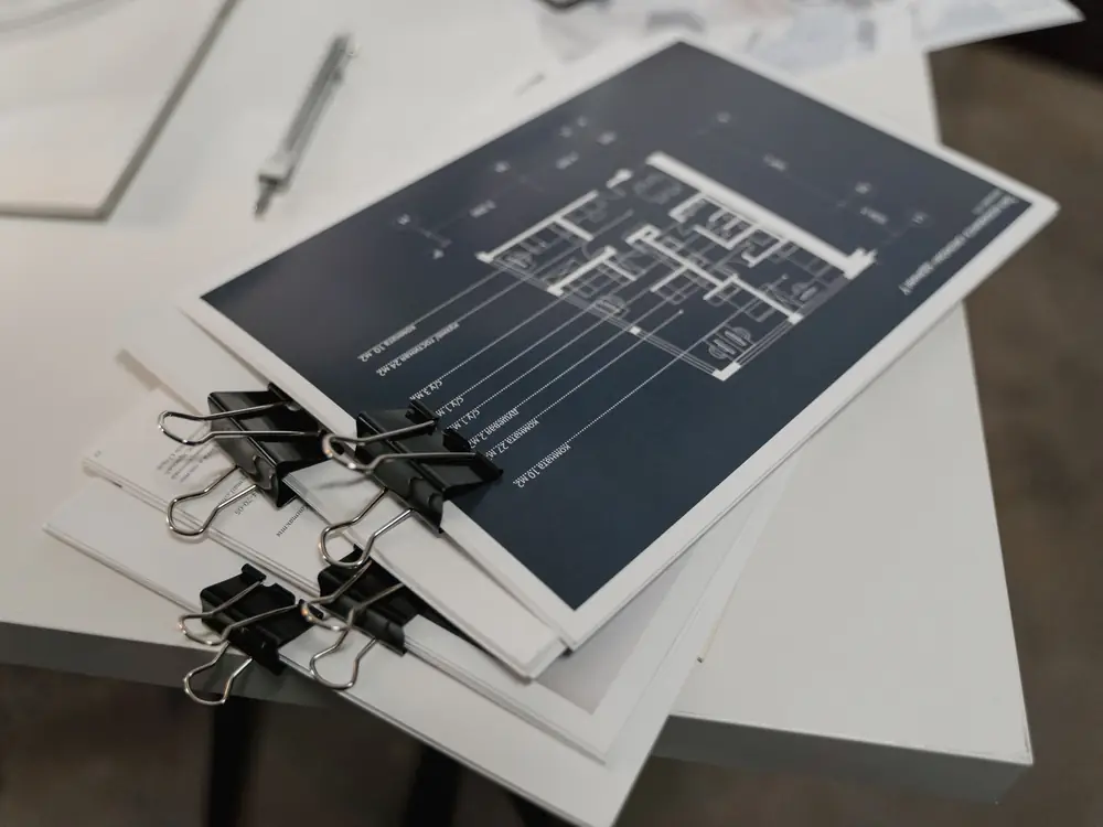 Blueprint sheets clipped together on a planning table